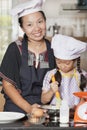 Mother and daughter using whisk to mix egg and wheat flour Royalty Free Stock Photo