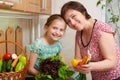 Mother and daughter with vegetables and fresh fruits in kitchen interior. Parent and child. Healthy food concept Royalty Free Stock Photo