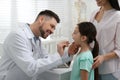 Mother with daughter visiting pediatrician in hospital. Doctor examining girl Royalty Free Stock Photo