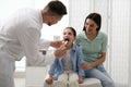 Mother with daughter visiting pediatrician in hospital. Doctor examining little girl Royalty Free Stock Photo