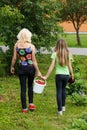 Mother and daughter walk home from the garden