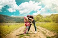 Mother and daughter walk on road through field