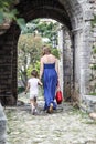 Mother and daughter walk among the ruins of the old town in Budv