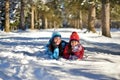 Mother and daughter on a walk in the woods on a snowy winter