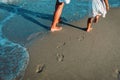 Mother and daughter walking on beach leaving footprint in sand Royalty Free Stock Photo