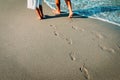 Mother and daughter walking on beach leaving footprint in sand Royalty Free Stock Photo