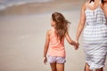 Enjoying a day at the beach with mom. A mother a daughter walking hand in hand on the beach. Royalty Free Stock Photo