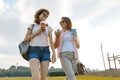 Mother daughter walking on the lawn in the park, The relationship between parent and child teenager, sunny summer day Royalty Free Stock Photo