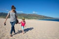 Mother and daughter walking on sand of Valdevaqueros Beach