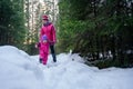 Mother and daughter walking a snowy forest.