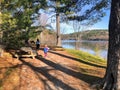 A mother and daughter walking together along a beautiful boardwalk path along the Gatineau River on a beautiful sunny fall day