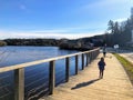 A mother and daughter walking together along a beautiful boardwalk path along the Gatineau River on a beautiful sunny fall day