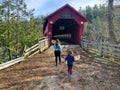 A mother and daughter walking together through the red Wakefield covered bridge along the Gatineau River Royalty Free Stock Photo