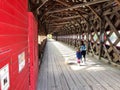 A mother and daughter walking together through the red Wakefield covered bridge along the Gatineau River Royalty Free Stock Photo