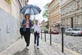 Mother and daughter walking under an umbrella along street Royalty Free Stock Photo