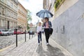 Mother and daughter walking under an umbrella along street Royalty Free Stock Photo