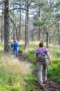 Mother and daughter walking in woods on sunny spring day