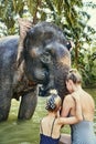 Mother and daughter washing an Asian elephant in a river