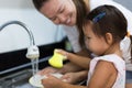 Mother and daughter washing dishes together at home Royalty Free Stock Photo