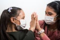 Mother and daughter wear medical masks and clasp hands in hopes that everything will pass. Coronavirus infection concept Covid-19 Royalty Free Stock Photo