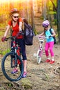 Mother and daughter wearing helmet are cycling on bicycles. Royalty Free Stock Photo