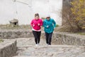 Mother and daughter wearing sportswear and running upstairs at c