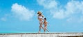 Mother and daughter running on a pier on the southern island Royalty Free Stock Photo