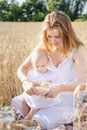 Mother and daughter in wheat field. Happy Family outdoors. healthy child with mother on picnic with bread and milk in golden