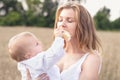 Mother and daughter in wheat field. Happy Family outdoors. healthy child with mother on picnic with bread and milk in golden