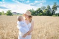 Mother and daughter in wheat field. Happy Family outdoors. healthy child with mother on picnic with bread and milk in golden