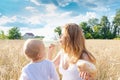 Mother and daughter in wheat field. Happy Family outdoors. healthy child with mother on picnic with bread and milk in golden