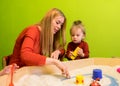 Mother and daughter white European people developing studies of early development with sand in the sandbox and more