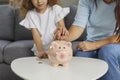 Mother and daughter who are planning to save up some money putting coins in piggy bank Royalty Free Stock Photo