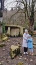 Mother and daughter in winter clothes stand near the dolmen in the reserve. Royalty Free Stock Photo