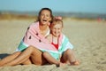 Mother and daughter wrapped in funny watermelon towel sitting