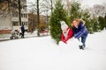 Mother with daughter of younger school age build a snowman in the yard.