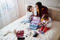 Mother and daughters doing makeup on the bed in the bedroom Royalty Free Stock Photo