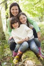 Mother and daughters outdoors in woods sitting Royalty Free Stock Photo