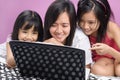 Mother and daughters playing with laptop