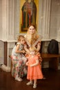 Mother daughters sit on bench in Church Orthodox