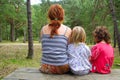 Mother and daughters sitting back park forest