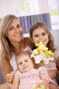 Mother and daughters smiling happily