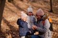 Mother with daughters wear jacket and hat in early spring forest Royalty Free Stock Photo