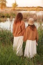 Mother day. Back view of young mom with little girl are standing near lake, pond on summer day. Family enjoying life Royalty Free Stock Photo