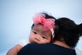 Mother day bonding concept with newborn baby nursing. Mother is holding newborn baby with flower pink headband with blue sky. Focu Royalty Free Stock Photo