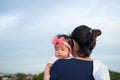 Mother day bonding concept with newborn baby nursing. Mother is holding newborn baby with flower pink headband with blue sky. Focu Royalty Free Stock Photo