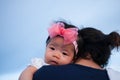 Mother day bonding concept with newborn baby nursing. Mother is holding newborn baby with flower pink headband with blue sky. Focu Royalty Free Stock Photo