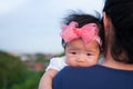 Mother day bonding concept with newborn baby nursing. Mother is holding newborn baby with flower pink headband with blue sky. Focu Royalty Free Stock Photo