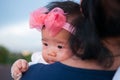 Mother day bonding concept with newborn baby nursing. Mother is holding newborn baby with flower pink headband with blue sky. Focu Royalty Free Stock Photo