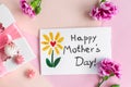 Mother day greeting card on pink background. Text Happy Mothers day. Breakfast, carnation gift and a postcard made by